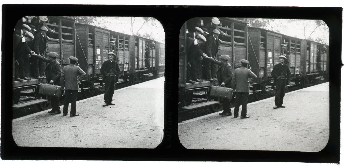 Hommes embarquant dans des trains de marchandise pour se rendre dans les casernes. 